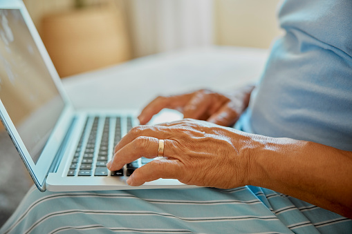 Senior man, laptop and hands doing pills research on living room sofa for side effects of prescription. Medicine, internet search and website of elderly person checking for drugs information at home